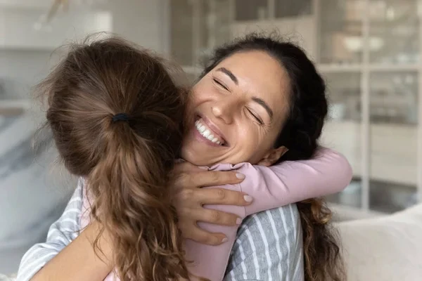 Mamá abrazando a su hija para que le enseñe cómo se demuestra el amor