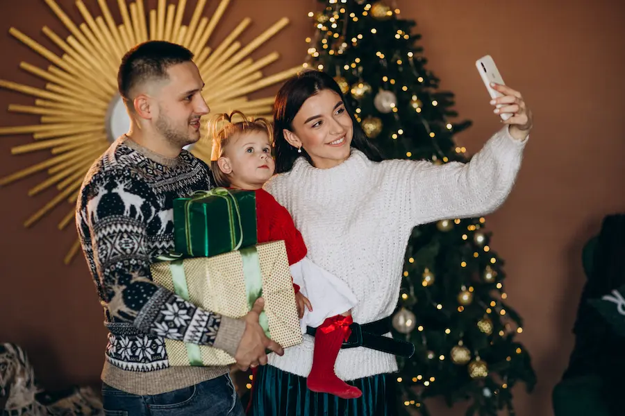 familia-con-hija-pequena-por-arbol-de-navidad