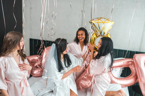 Grupo de amigas brindando sonrientes con copas en una despedida de soltera elegante.